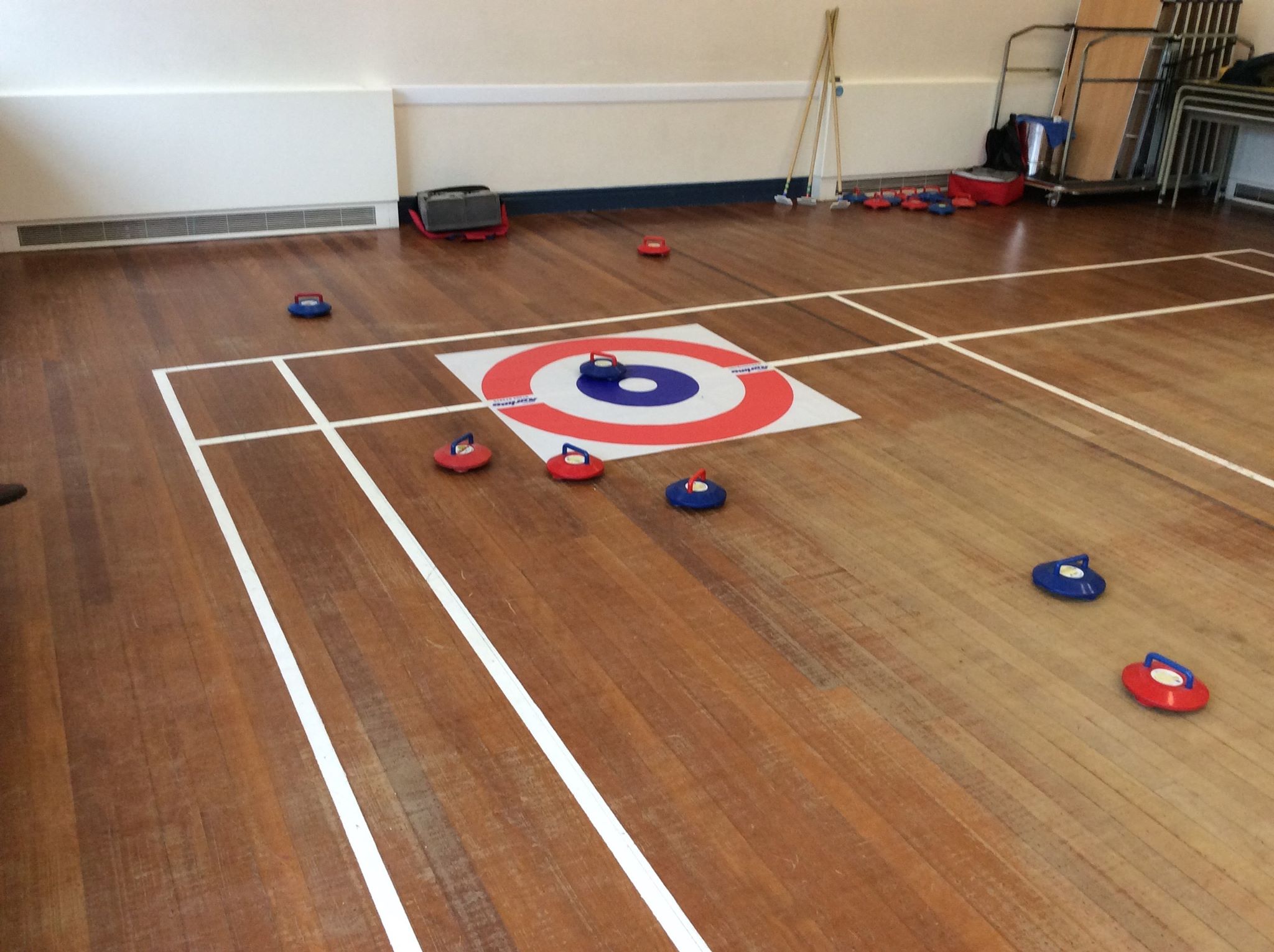 Kurling stones surrounding a target on the floor.